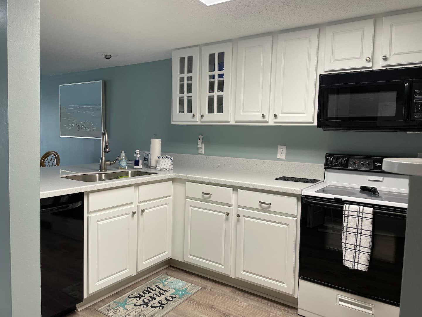 Kitchen with white cabinets and full appliances