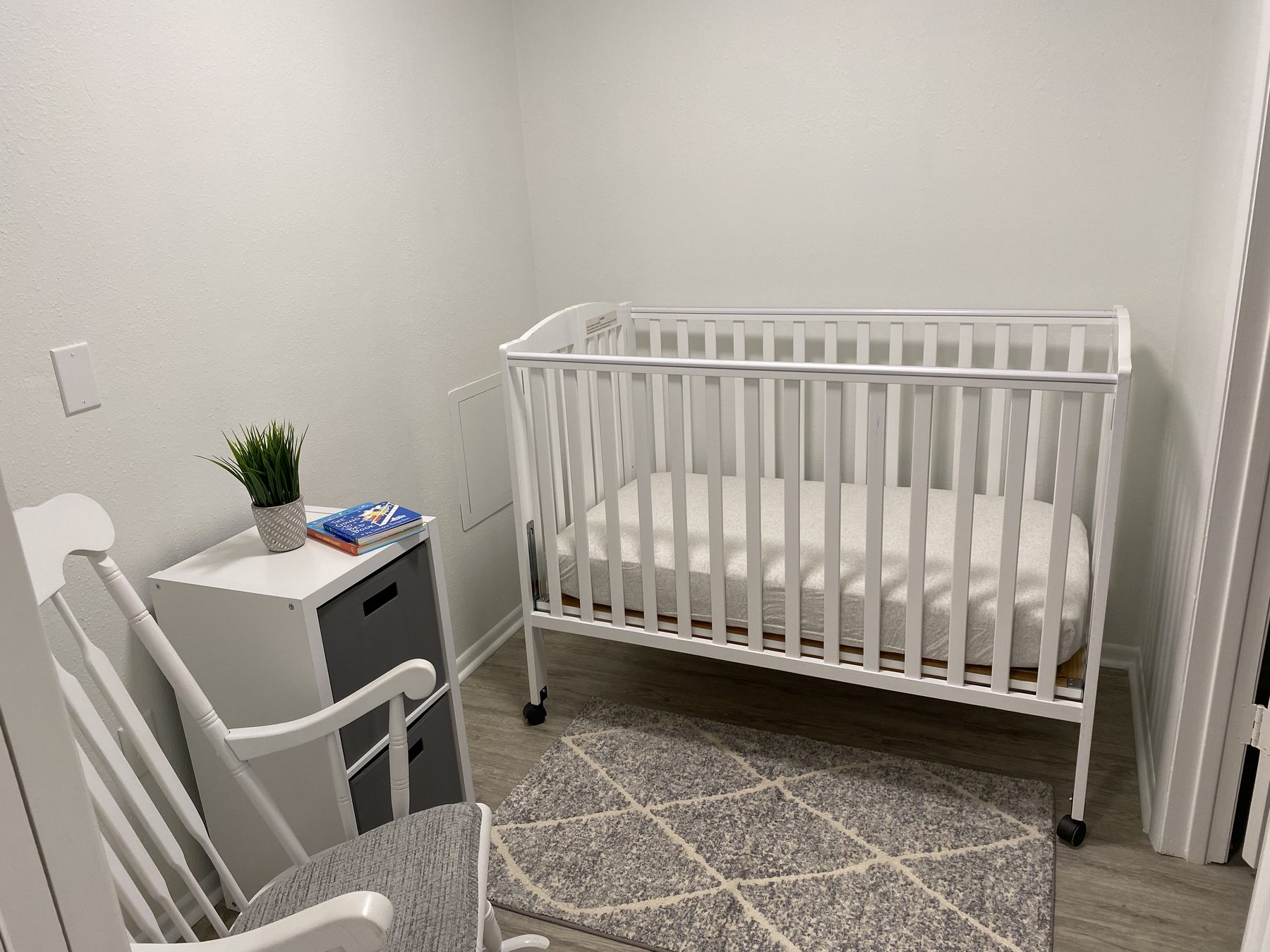 Full-size crib and rocking chair adjacent to the primary bedroom